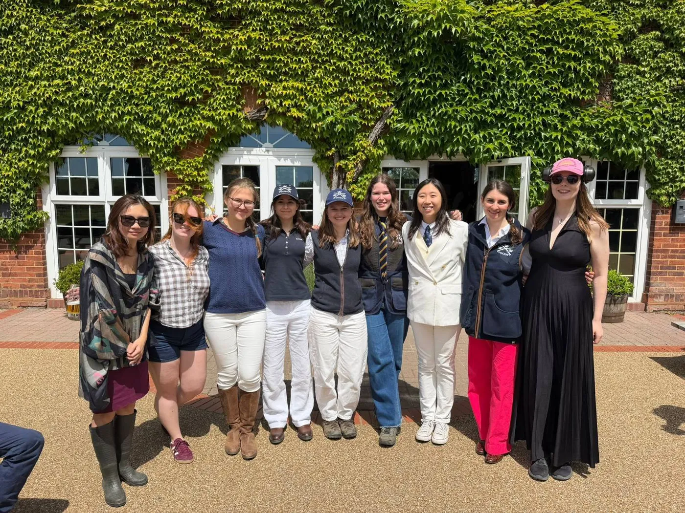 Members of the ladies' team outside an ivy-covered clubhouse